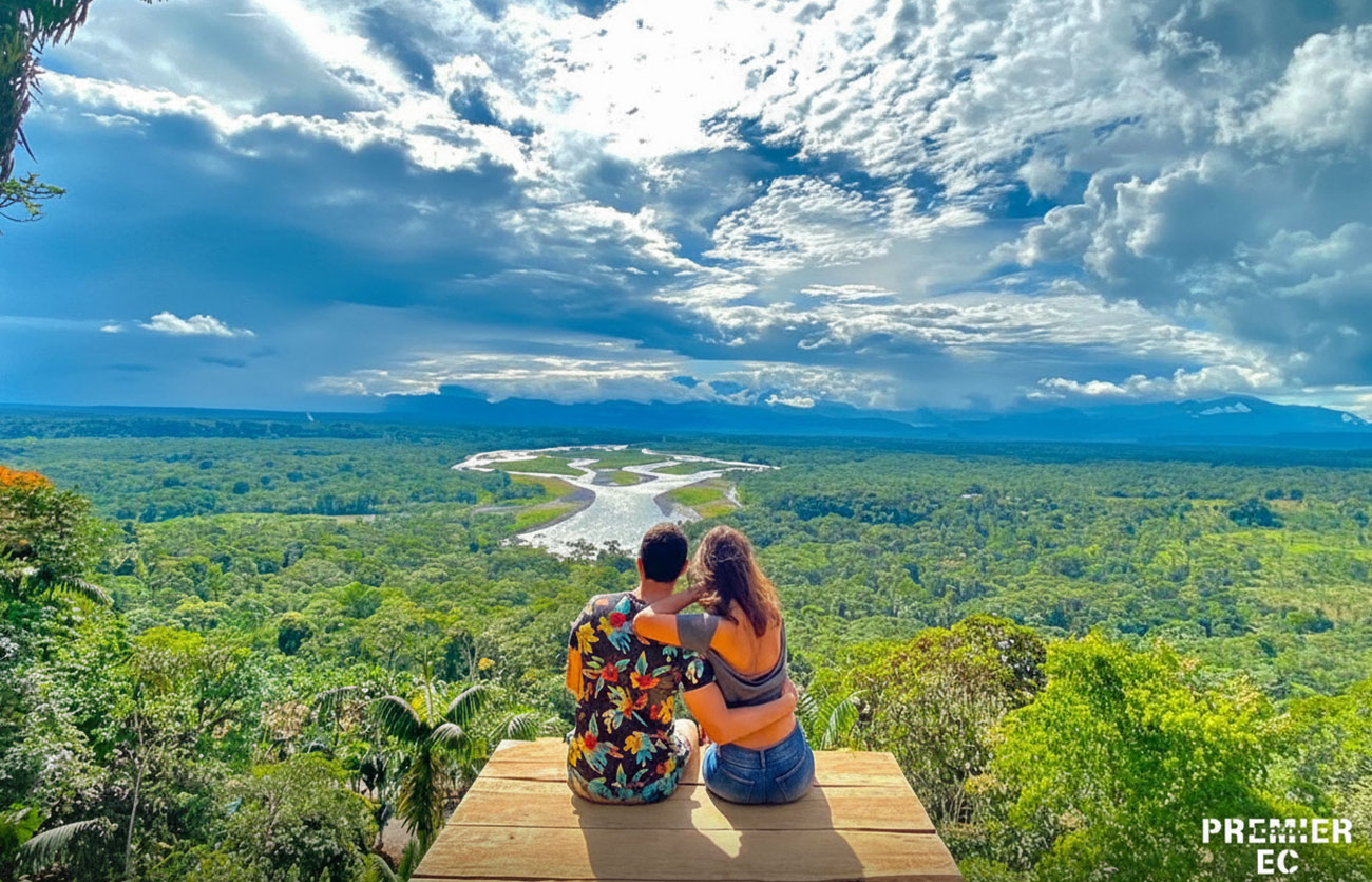 Turistas disfrutando de la vista panorámica al río Puyo y la selva amazónica desde el Mirador Indichuris, durante un tour en Ecuador